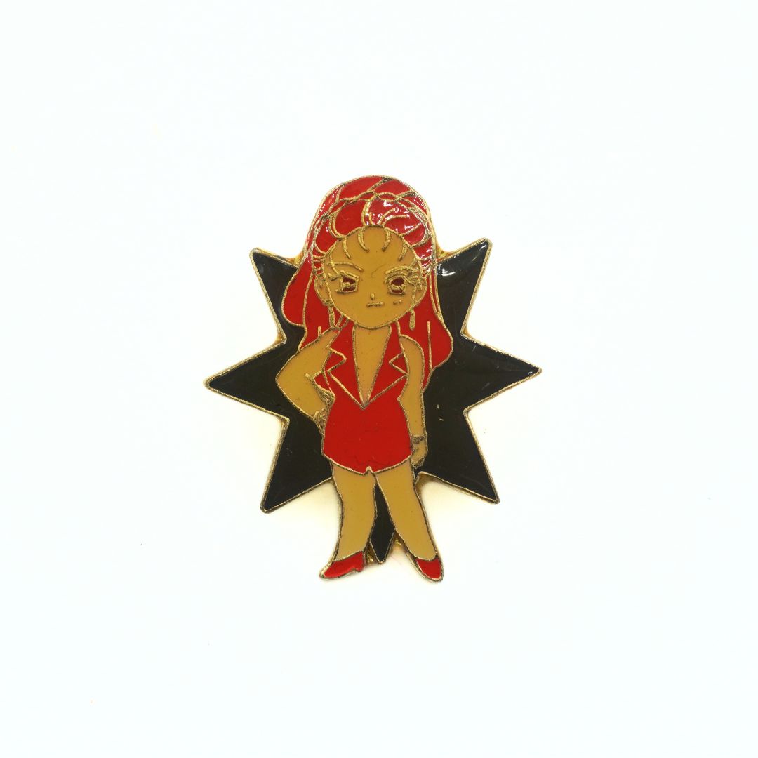 Pin with a character in a red outfit and headscarf on a black star background