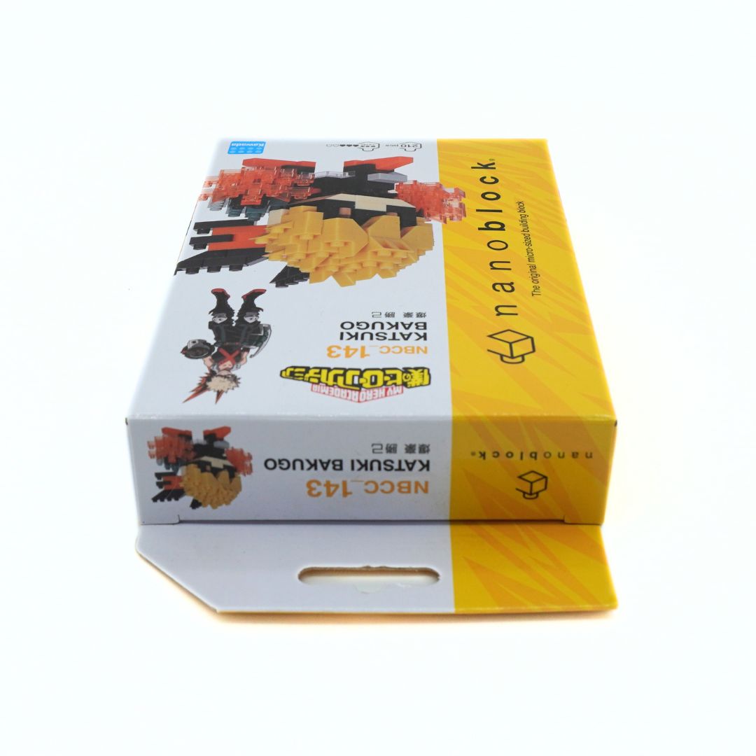 A boxed toy building block set labeled 'nanoblock' and 'KATSUKI BAKUGO' on a plain white background. The box is mostly white with a large yellow side panel and printed product imagery.