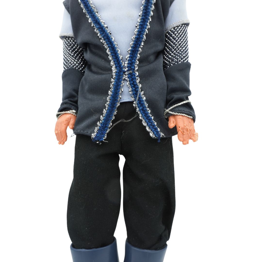 Doll wearing a dark gray cardigan with blue trim on a white background