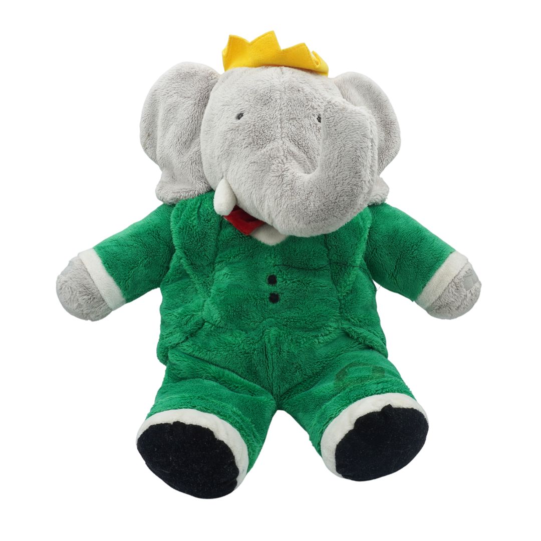 Plush elephant toy wearing a green outfit and yellow crown on a white background