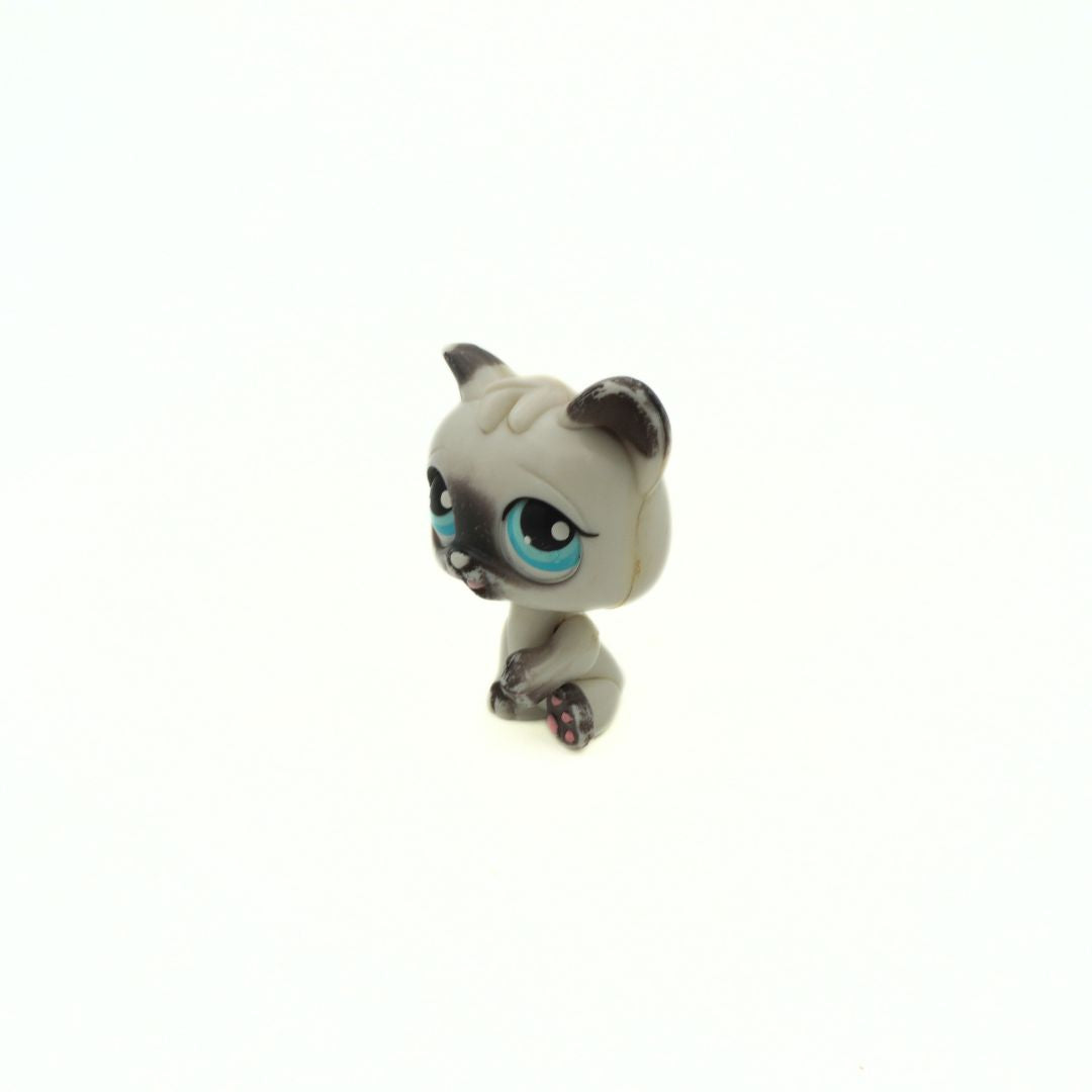 Small figurine of a cat with large blue eyes on a white background