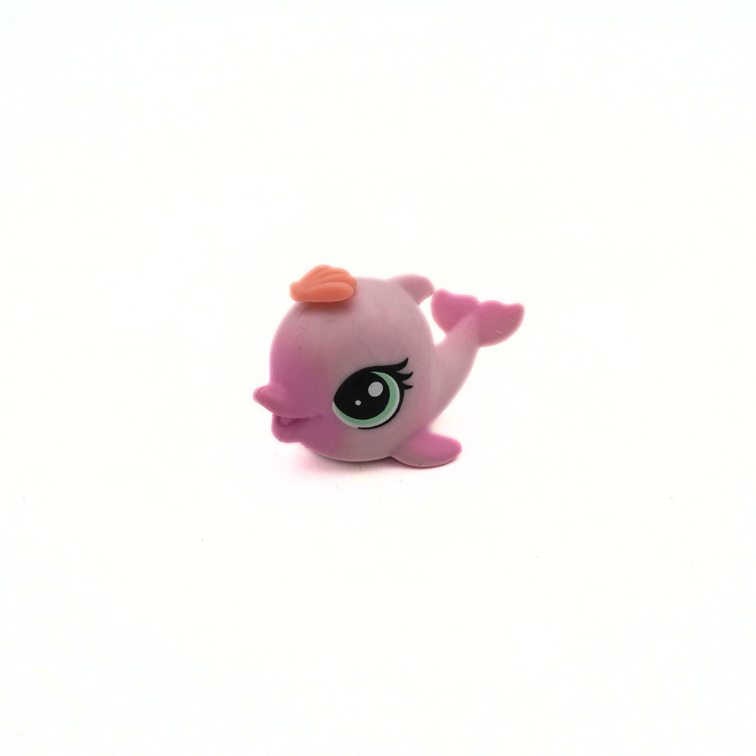 Pink dolphin figurine with an orange shell on a white background