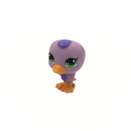 Small purple toy figure with green eyes and orange beak on a white background