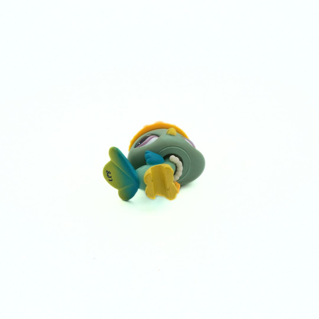 Underside of a vintage Peacock LPS toy with a green body and yellow feet