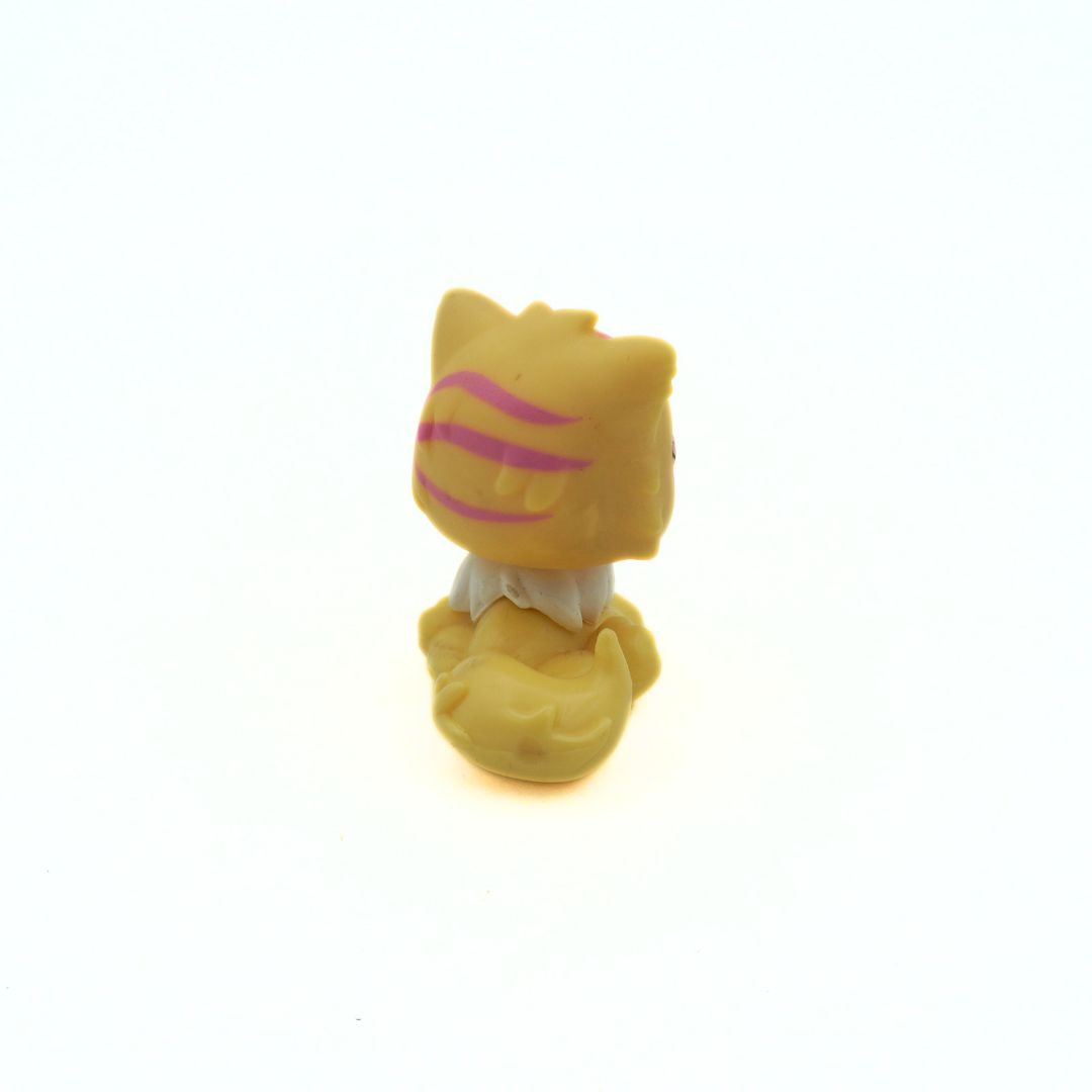 Small yellow cat figurine with pink stripes on a white background