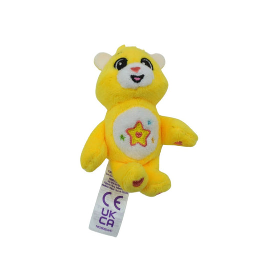 A small yellow plush bear toy with a white belly patch featuring a star design, attached to a white UKCAI tag, shown against a plain white background.