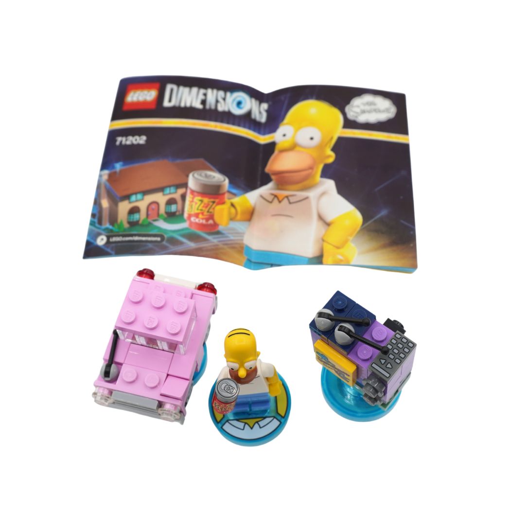 LEGO Dimensions Simpsons set 71202, showing the open instruction booklet with Homer Simpson and the assembled toy pieces: a pink car, a small Homer figure, and a blue and purple buildable accessory, all on a white background.