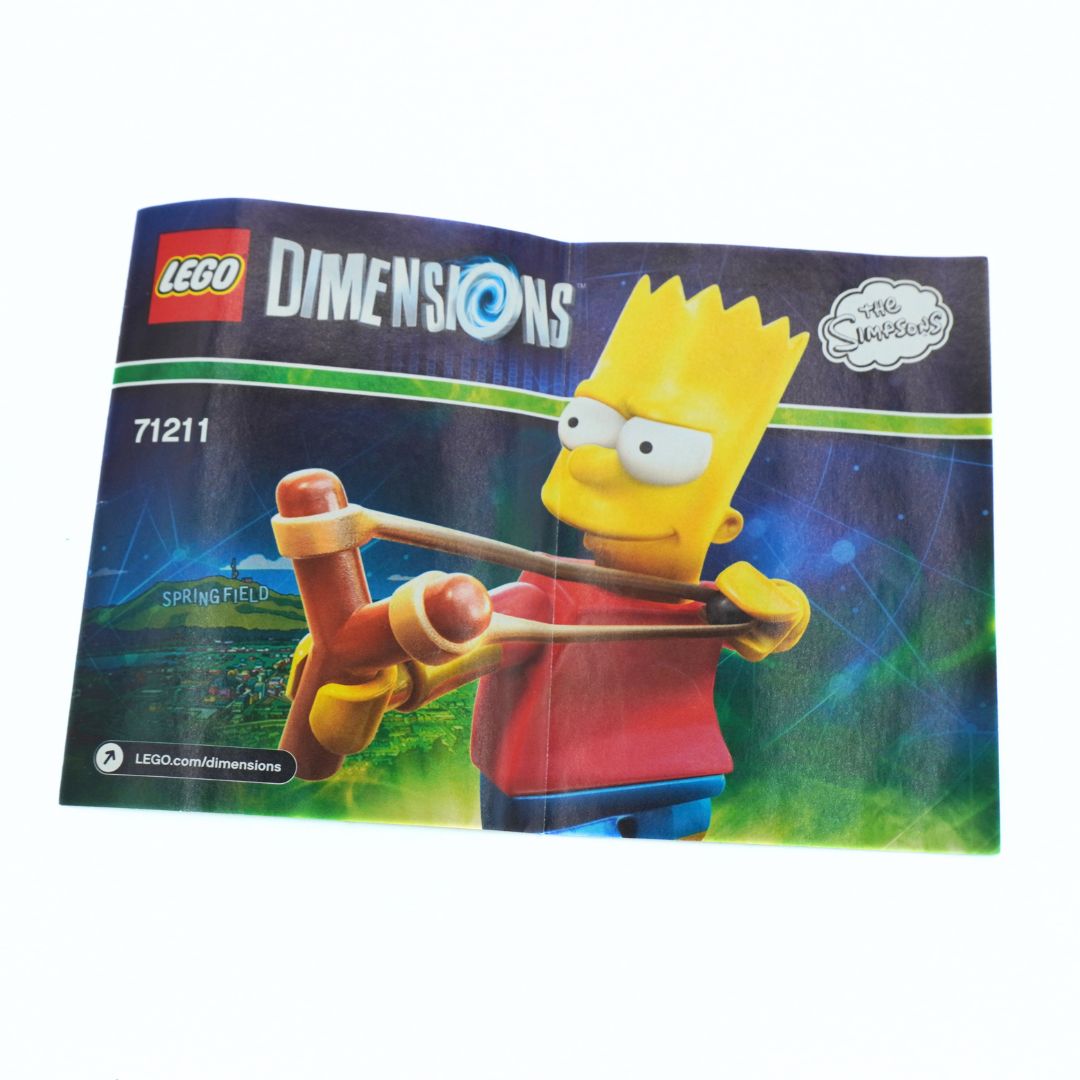 LEGO Dimensions 'The Simpsons' Bart Simpson Springfield set booklet, showing the LEGO logo, Dimensions branding, set number 71211, and a graphic of Bart Simpson holding a slingshot, photographed on a white background.