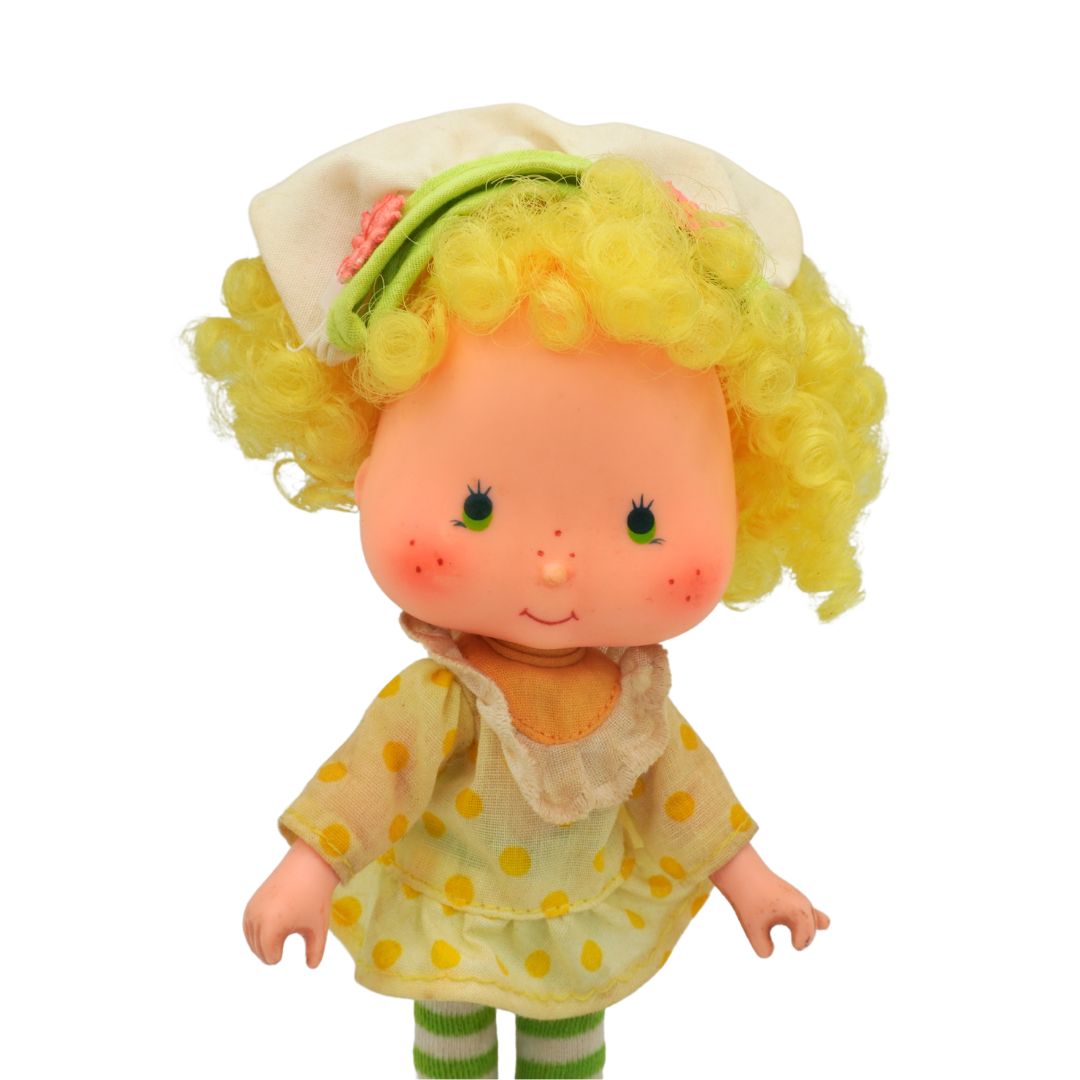 Toy figure with yellow hair and dress on a white background