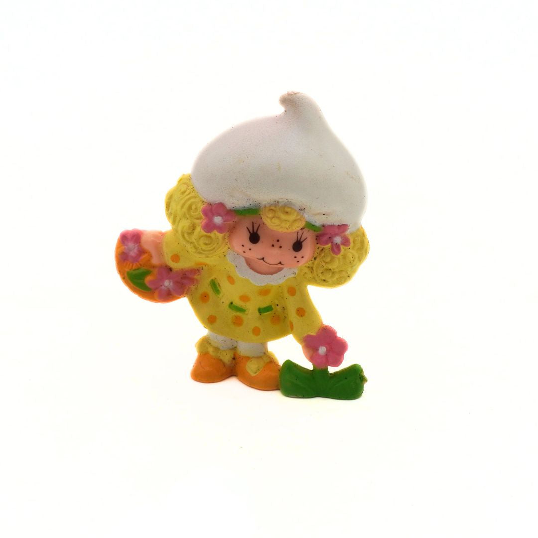 Colorful Strawberry Shortcake figurine with a white hat on a white background