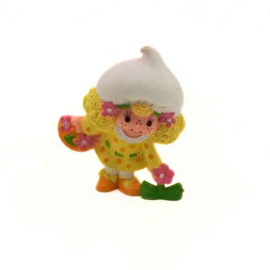 Colorful Strawberry Shortcake figurine with a white hat on a white background