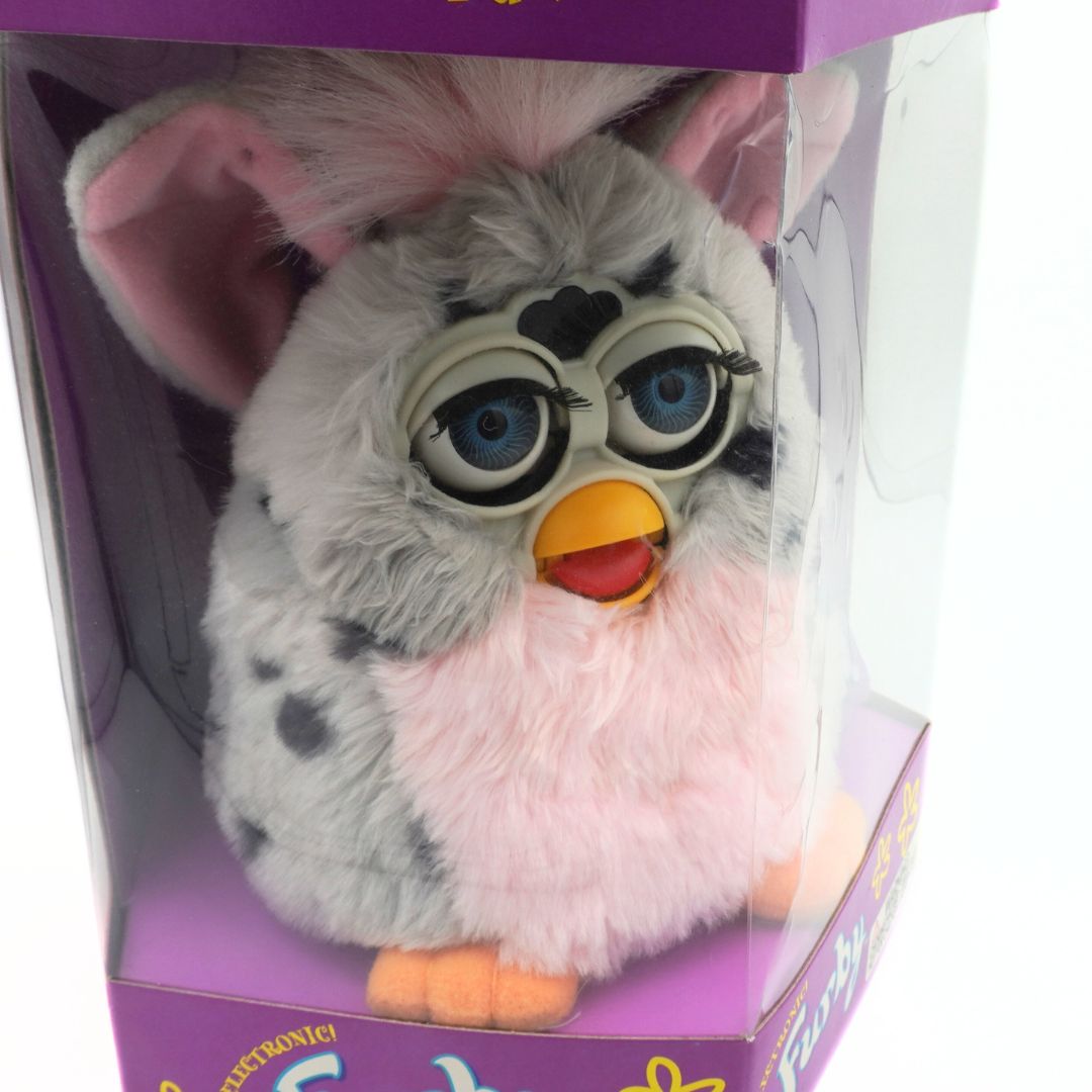 Plush toy resembling a character from Furby in packaging