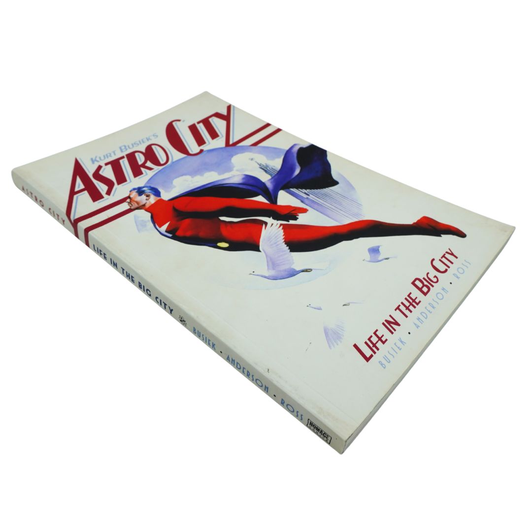 A vintage hardcover book titled 'Astro City' by Keith Busiek, featuring a retro illustration of a flying figure on the cover, photographed on a plain white background.