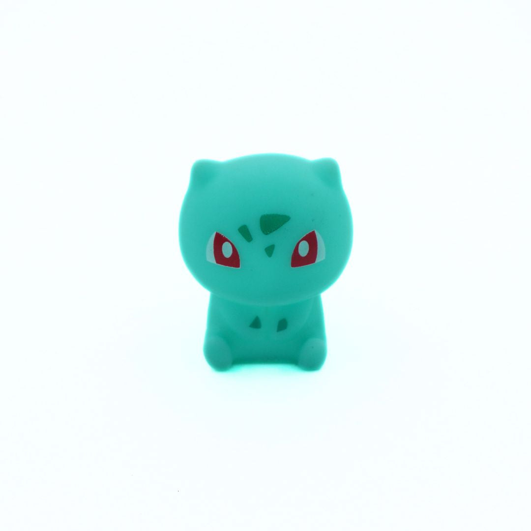 Green plush toy with red eyes on a white background