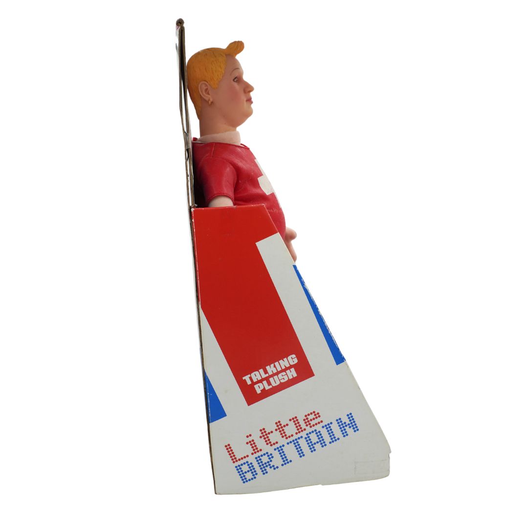 Talking Plush Little Britain toy figure in its original packaging, featuring the character in a red shirt and yellow hair, set against a plain white background.