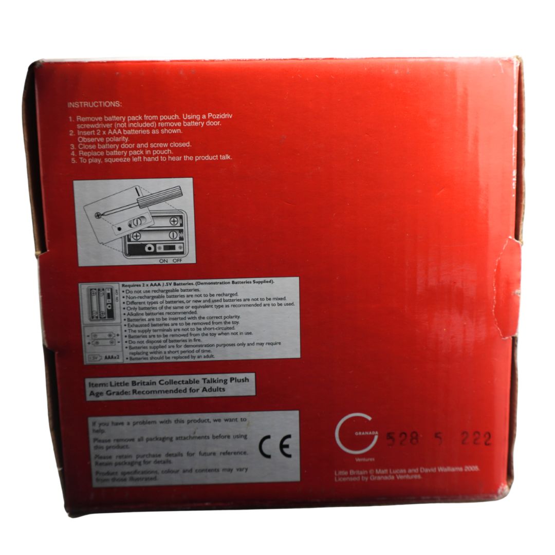 The back of a red product box with printed instructions, diagrams, and a CE mark, photographed against a dark background.
