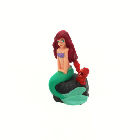 Mermaid figurine with red hair and green tail on a white background
