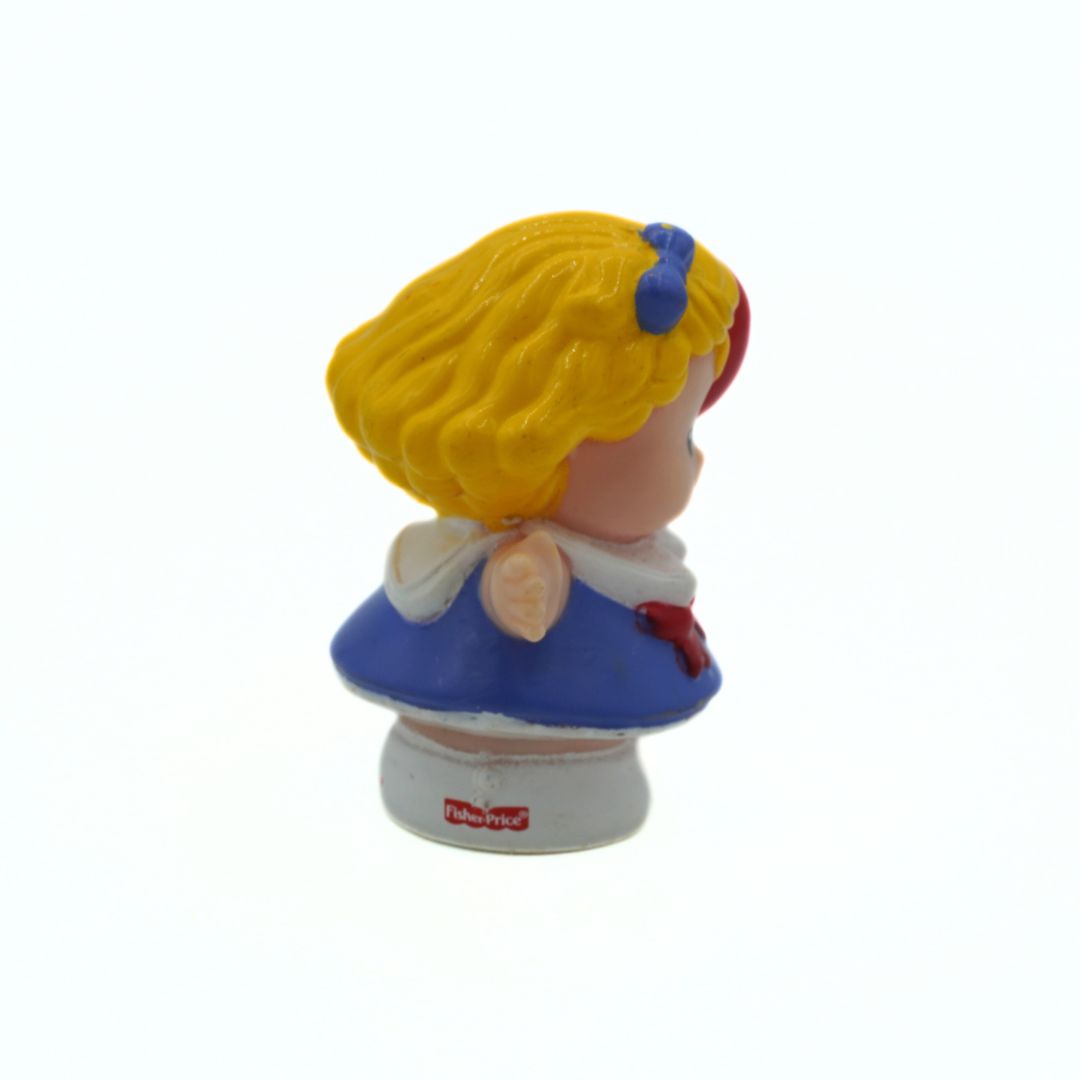 Toy figure of a character with yellow hair and a blue dress on a white background