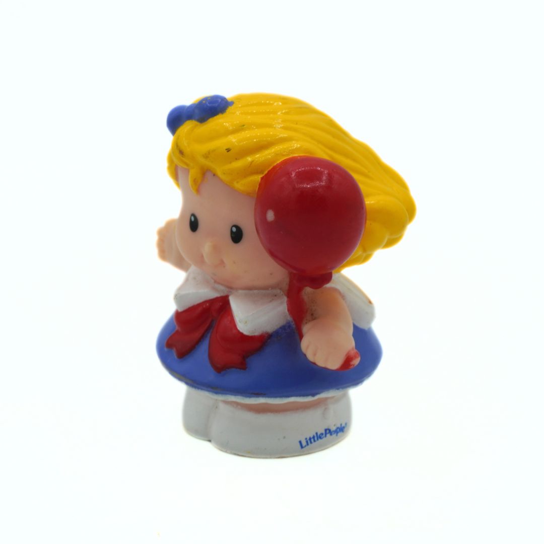 Toy figure of a girl with a red balloon on a white background