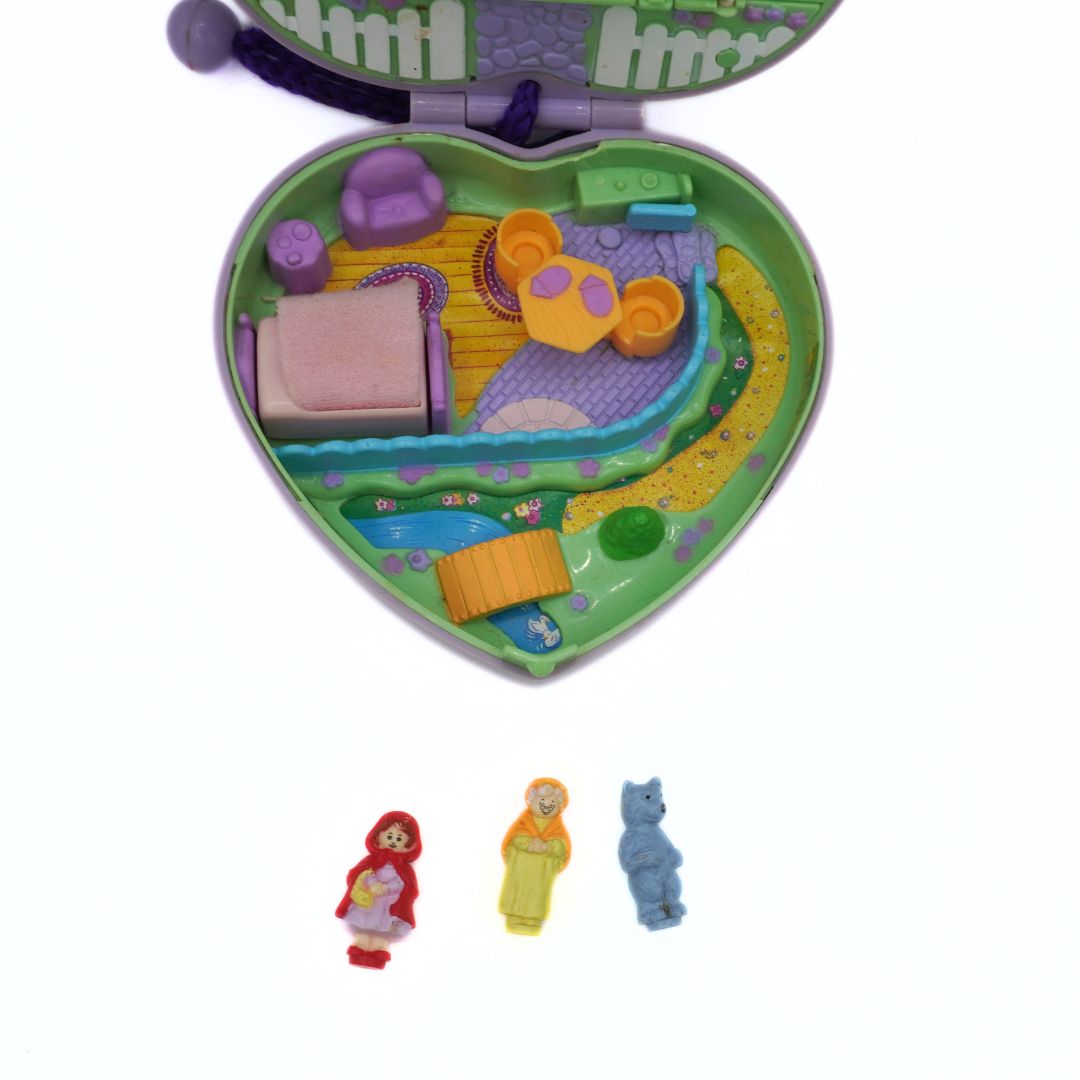 Toy set with a heart-shaped playset, figures, and accessories on a white background
