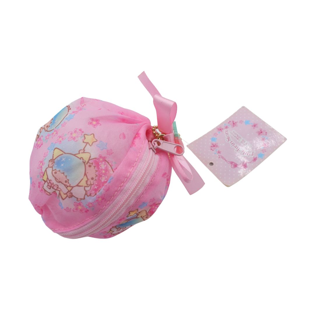A pink Sanrio key pouch with a cute character print, a pink ribbon bow, and a matching pink hangtag, shown on a plain white background.