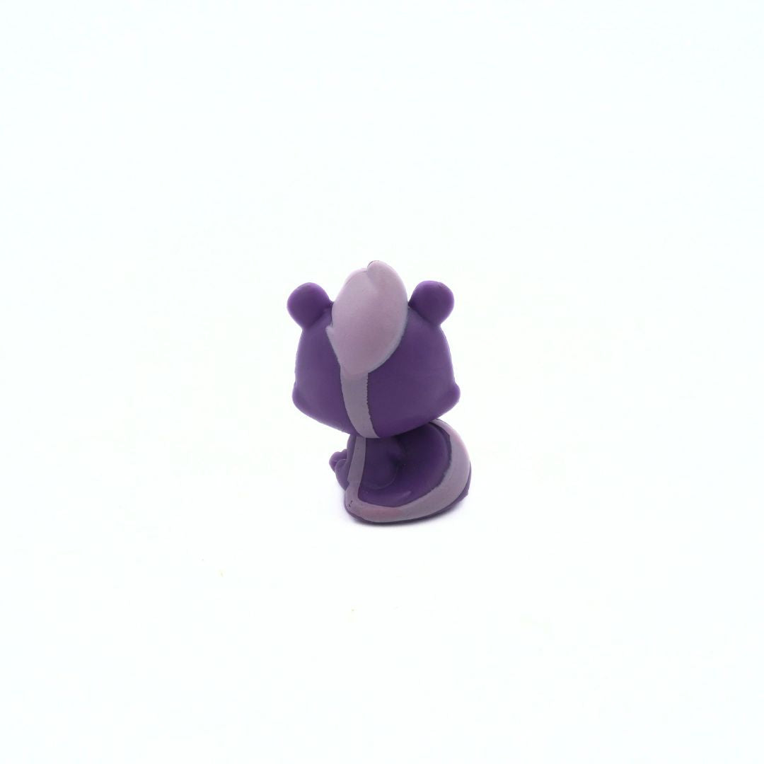Small purple and white figurine on a white background