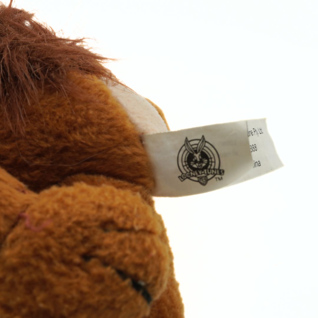 Close-up of a plush toy with a brand tag on a white background