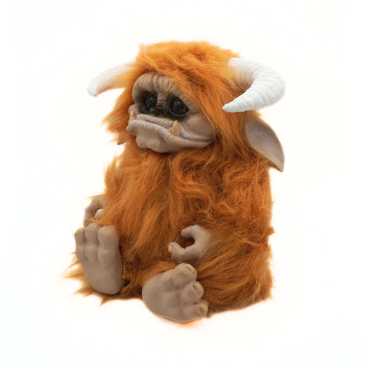 Plush toy resembling a creature with orange fur and white horns on a white background
