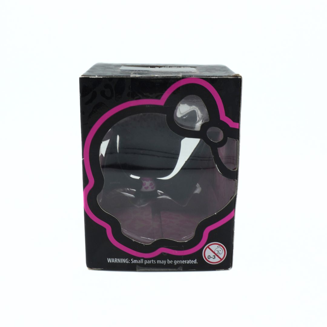 Back of a box holding a black and pink vinyl figure