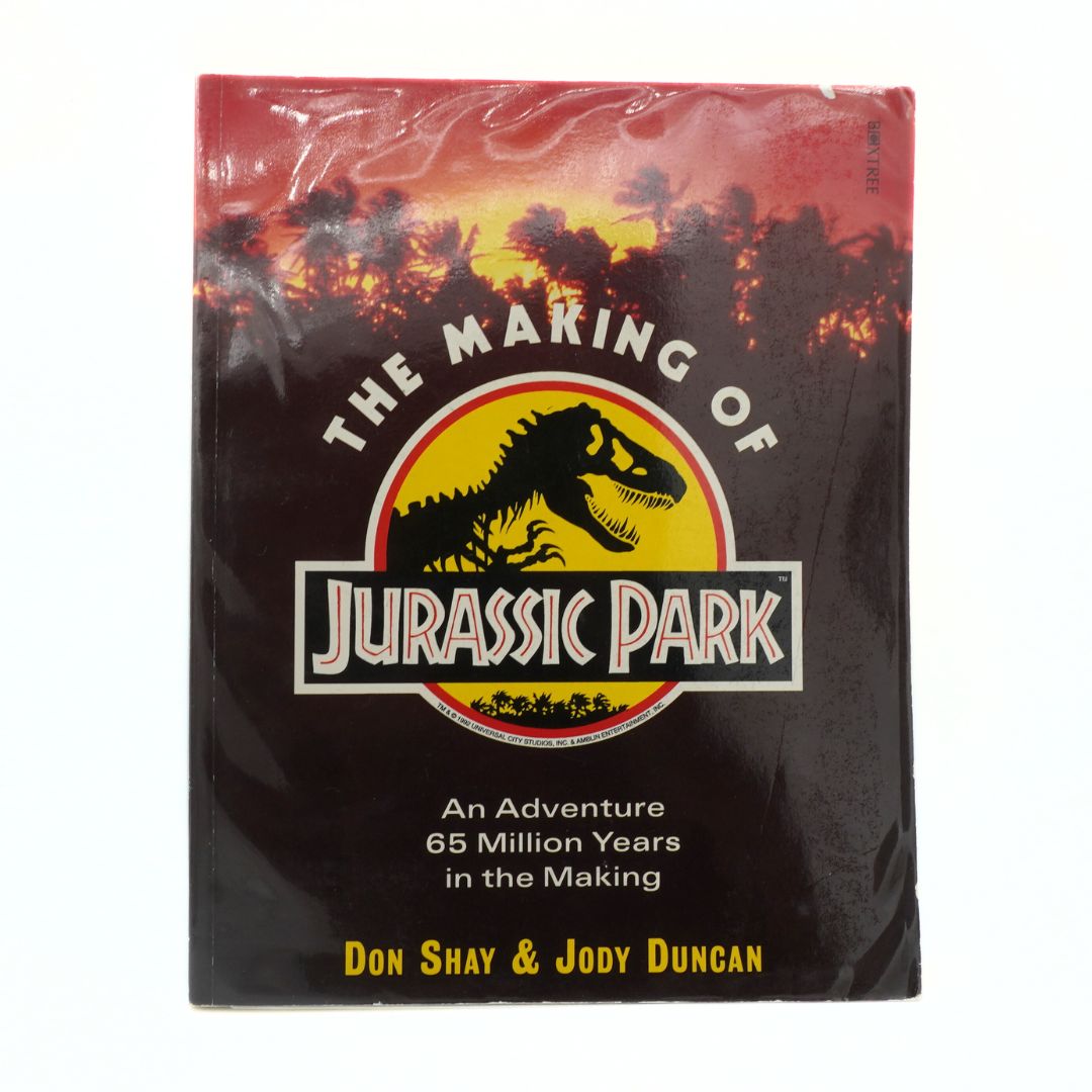 Book cover of 'The Making of Jurassic Park' with a dinosaur logo and text.