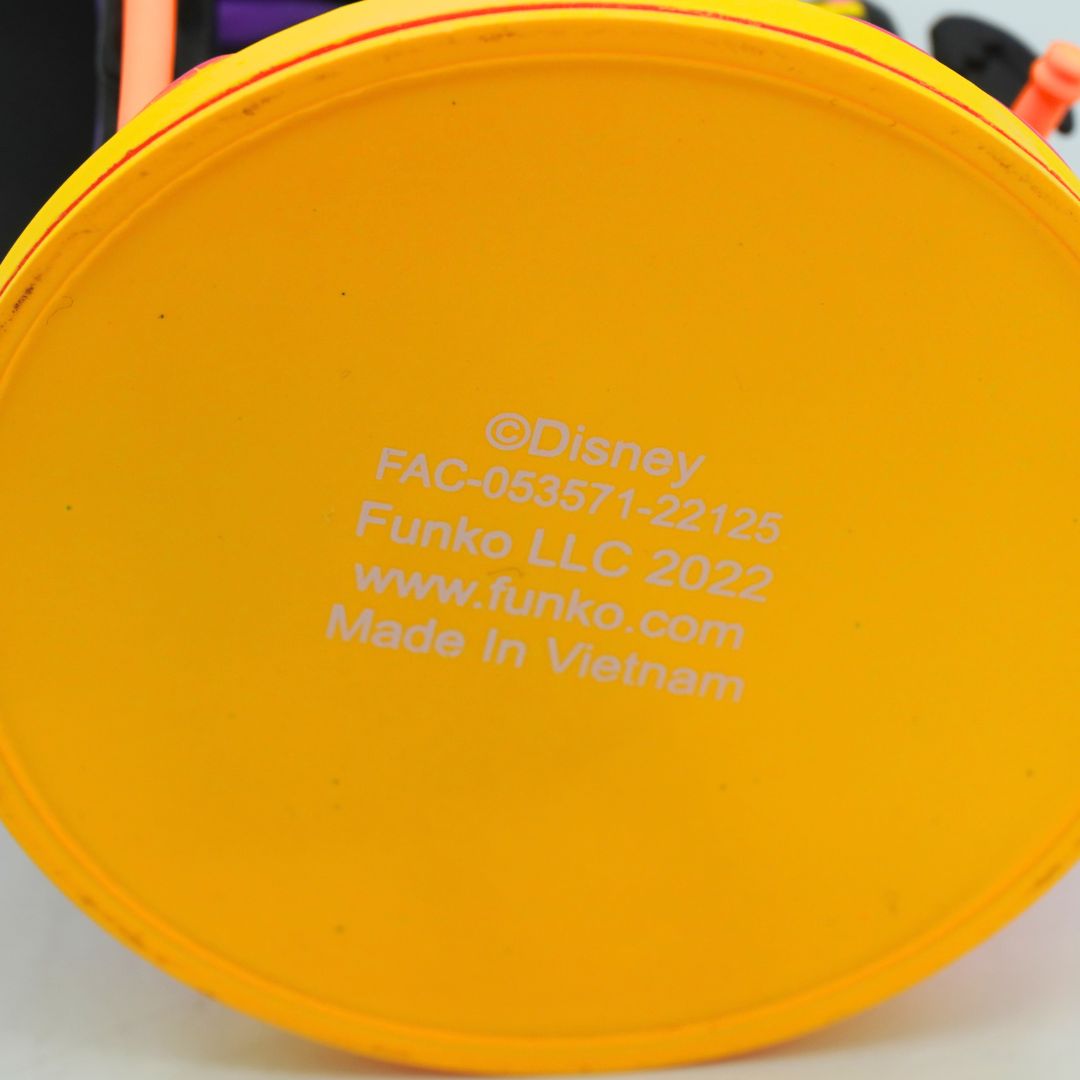 Close-up of the yellow plastic bottom of a Funko collectible item, showing white printed copyright text for Disney and Funko LLC 2022.