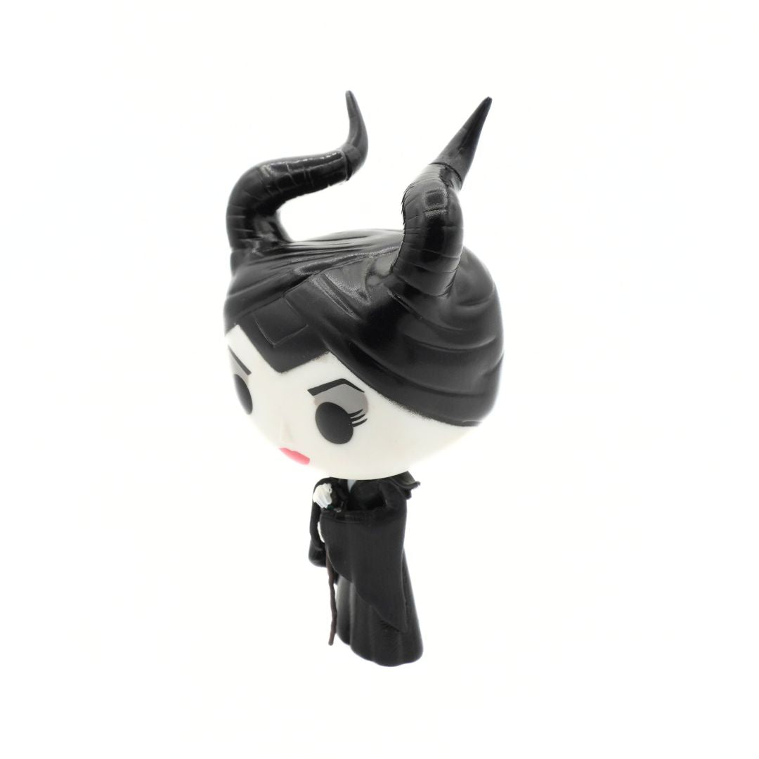 A stylized vinyl figure of Maleficent, featuring her signature black horns, black hair, and black dress against a plain white background.