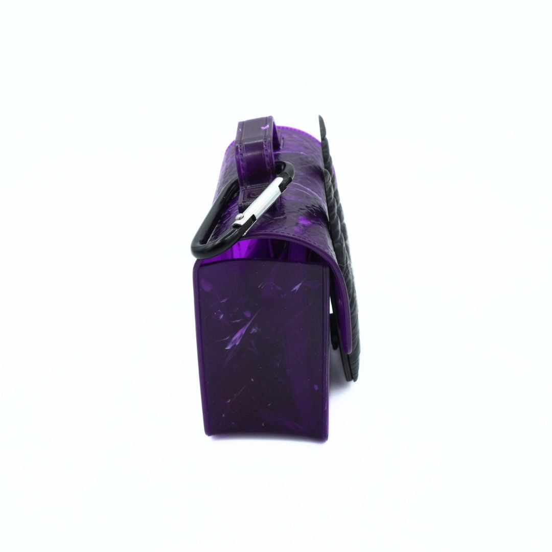 A small purple translucent handbag with a black carabiner attached to a strap, shown from a side angle on a plain white background.