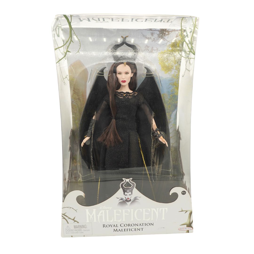 Maleficent Royal Coronation doll in its original clear plastic window packaging, featuring the character in a black gown with wings on a white and black display base.