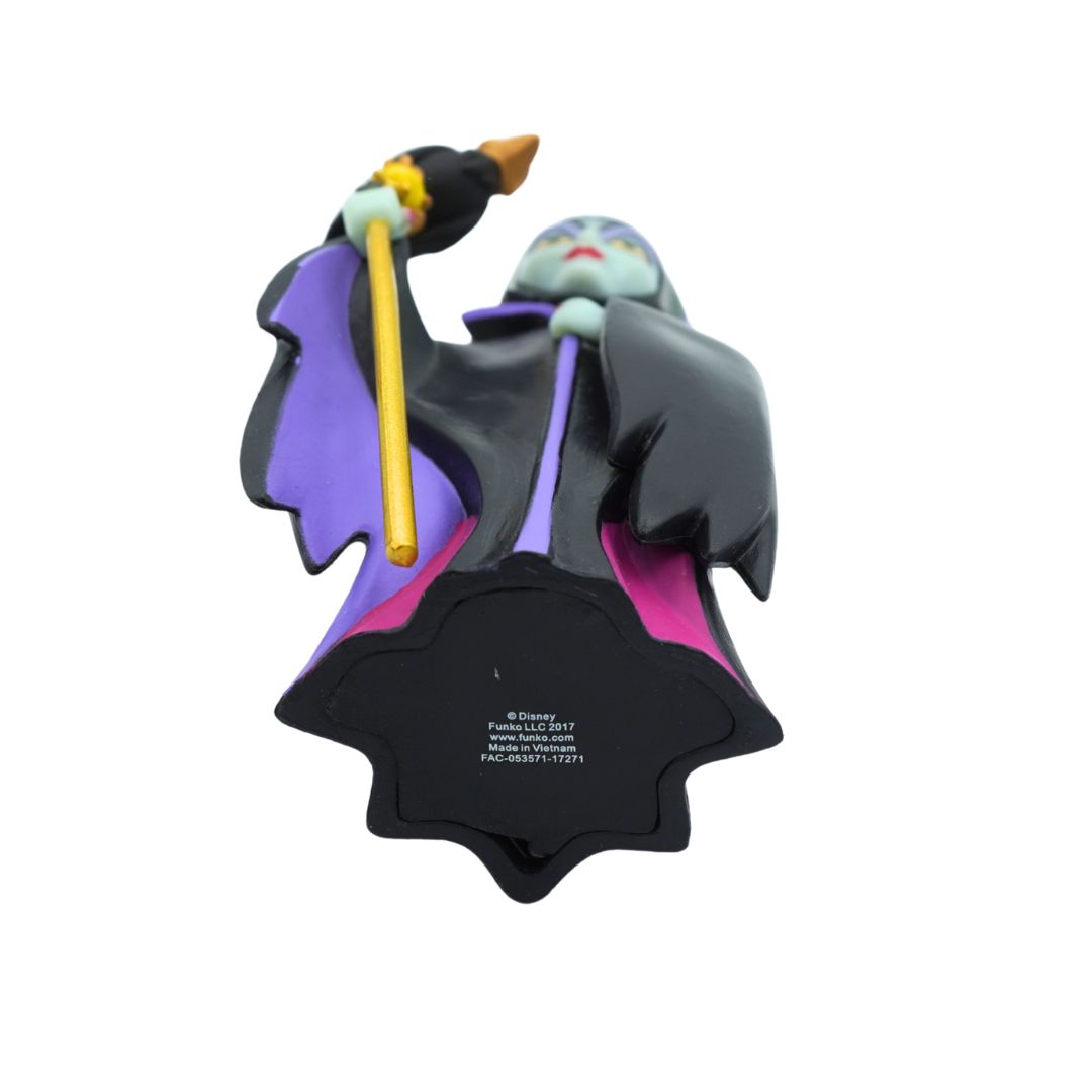 A Funko Pop! collectible figure of Maleficent, shown from the back to display the printed product code and copyright details on the black base. She is wearing her signature black and purple cloak with pink lining, holding a gold staff, and has a pale green skin tone.