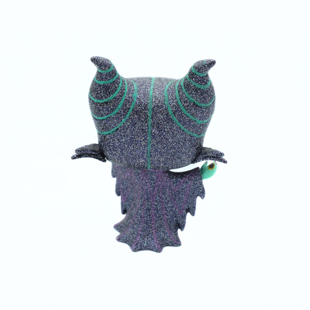 Back of a glittery Maleficent Funko made from vinyl. She is wearing black, green and purple and standing on a white background
