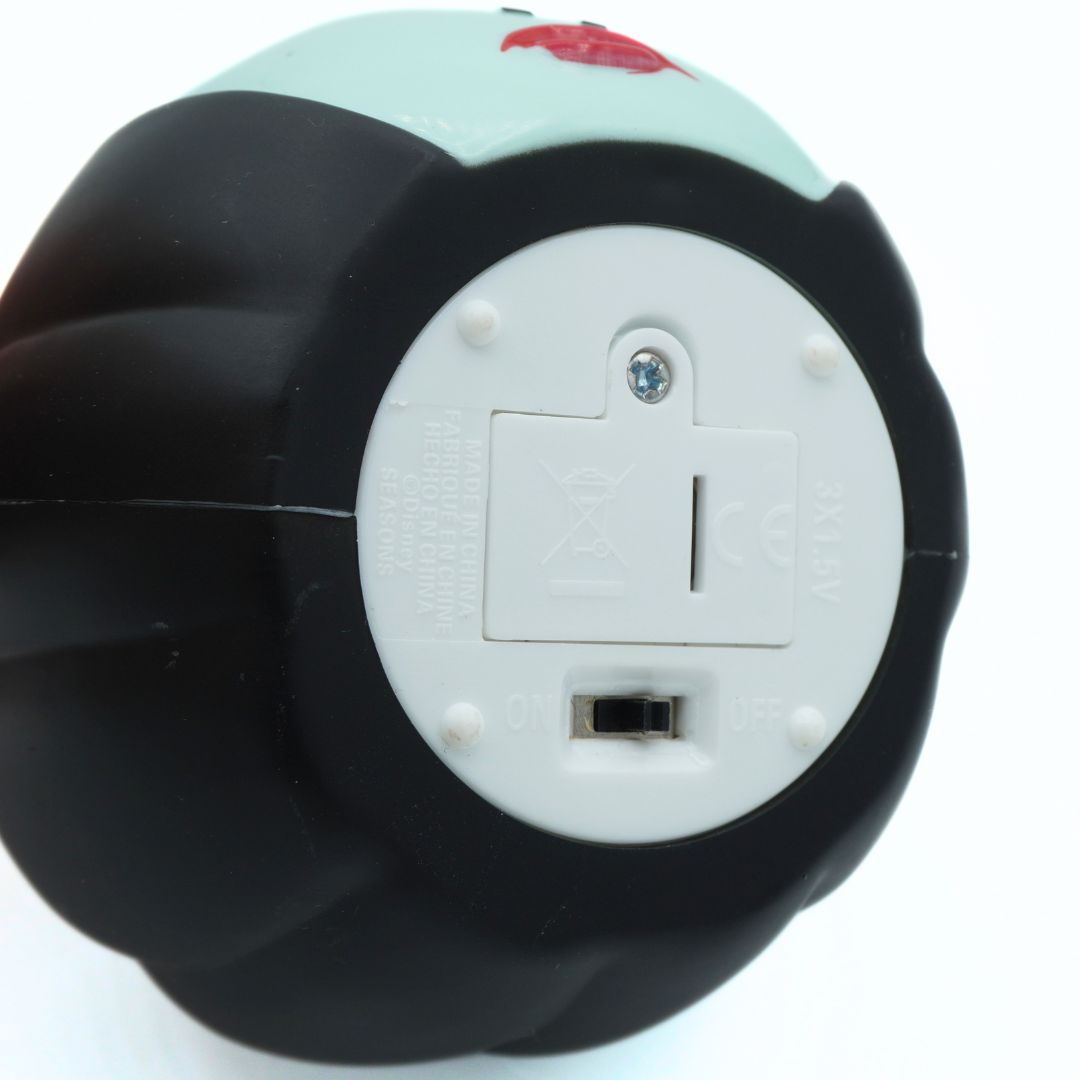 Close-up of the bottom outlet end of a black and mint green rounded product, showing a white circular socket cover with a small switch.