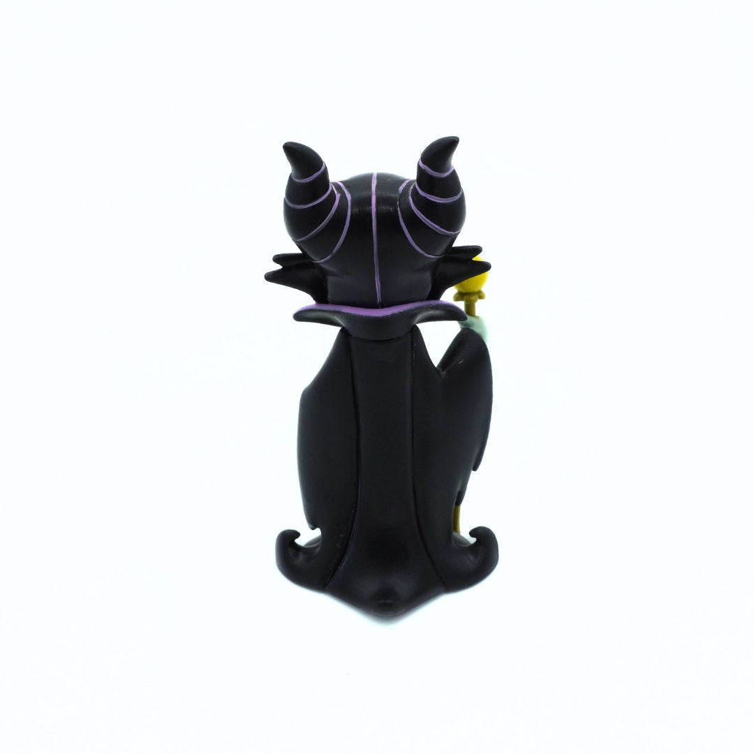A black vinyl figure of Maleficent from Disney's Sleeping Beauty, shown from the back holding a small yellow and green flower, set against a plain white background.
