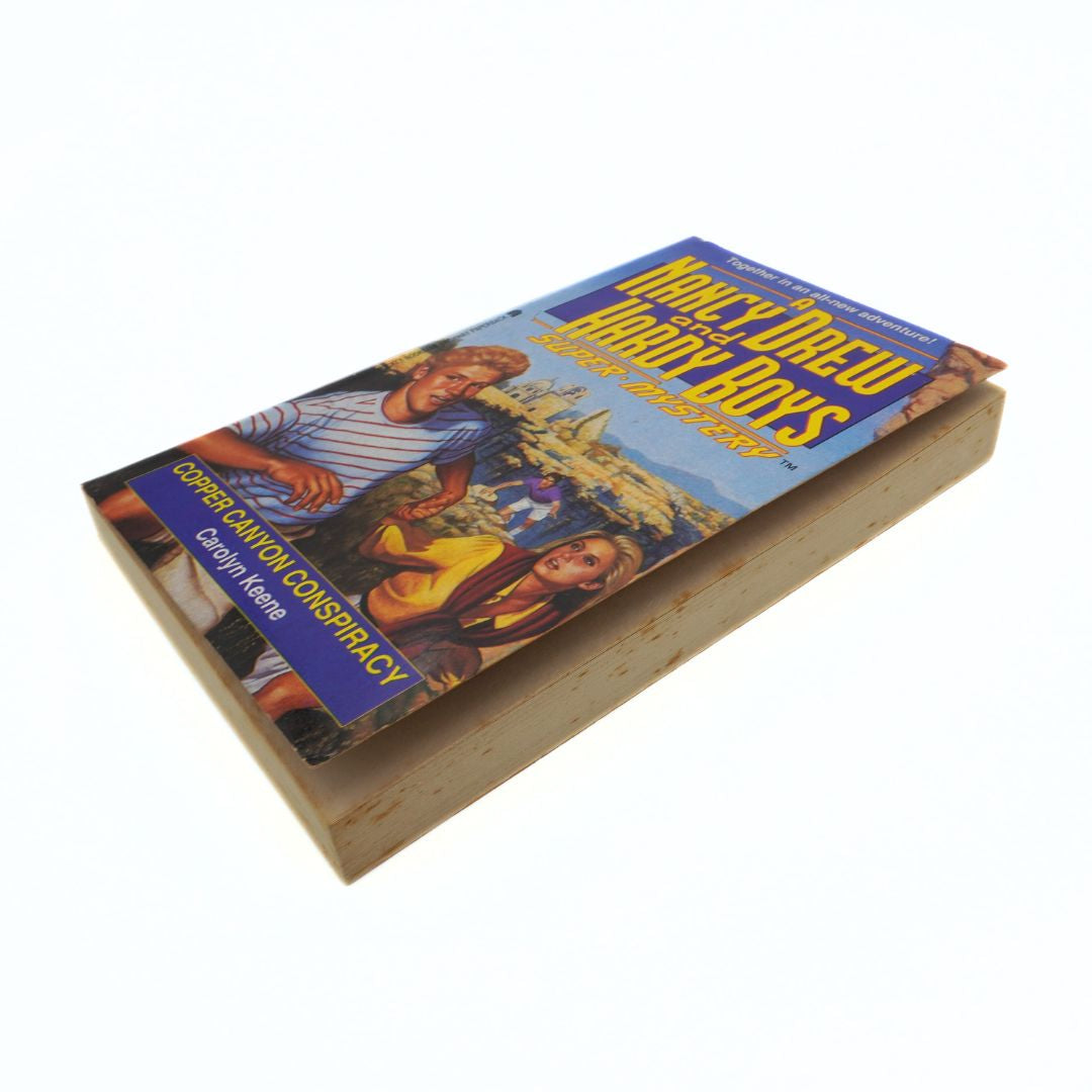 Book titled 'Canyon Conspiracy' from Nancy Drew series on a wooden surface