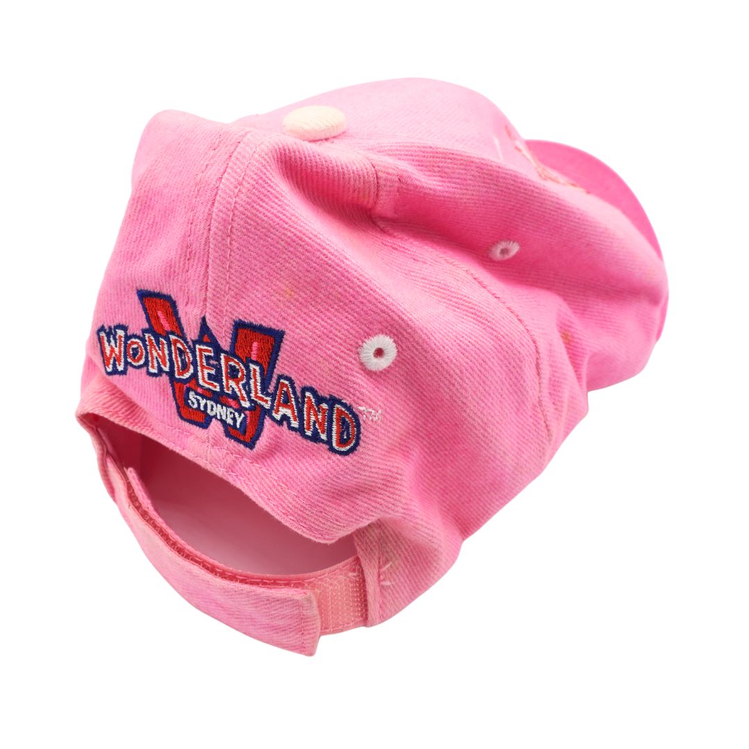 A pink cotton baseball cap featuring an embroidered 'WONDERLAND SYDNEY' graphic on the front, displayed against a solid white background.