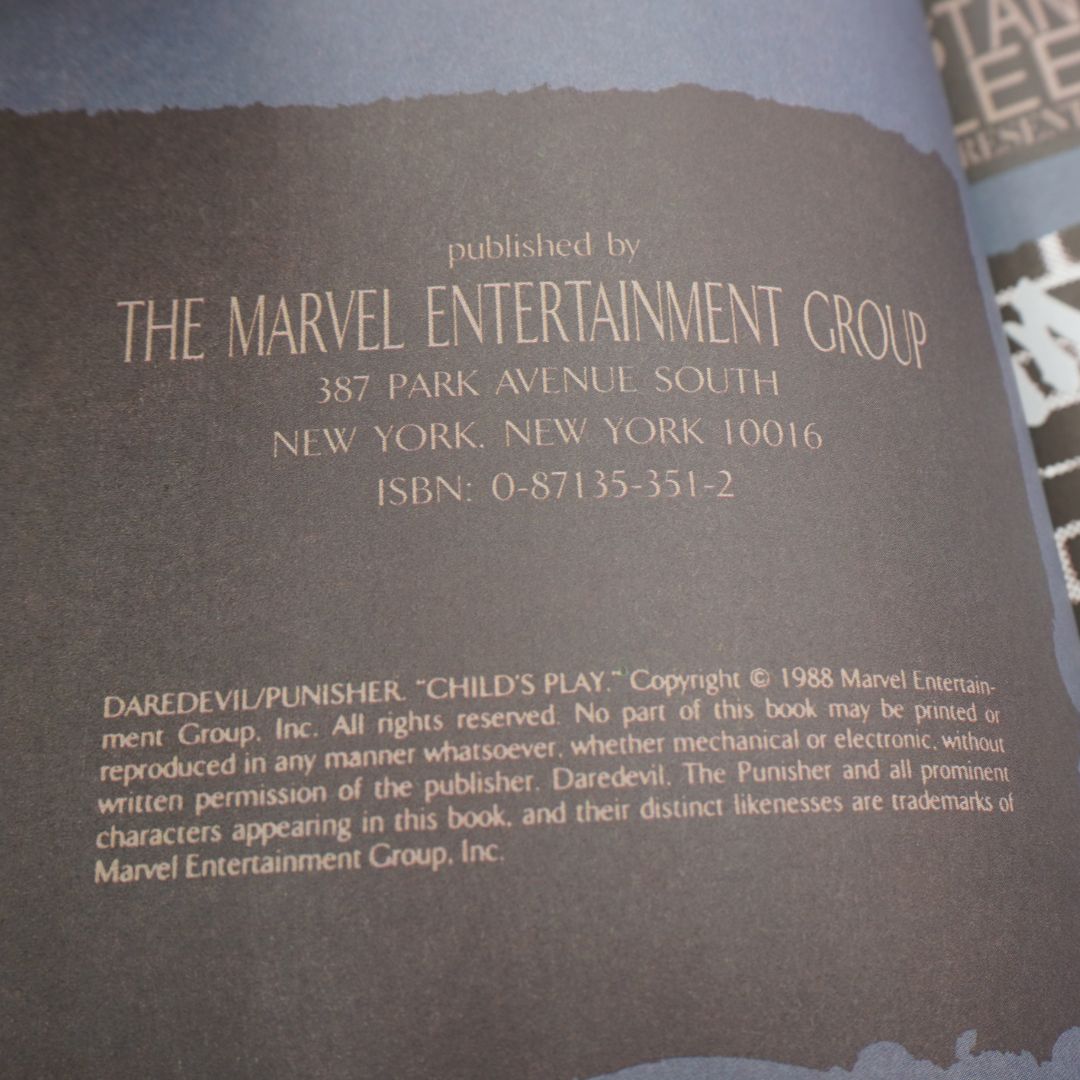 A close-up of a book's copyright page showing 'published by THE MARVEL ENTERTAINMENT GROUP' with publisher address, ISBN, and Daredevil/Punisher copyright text on a dark gray page.
