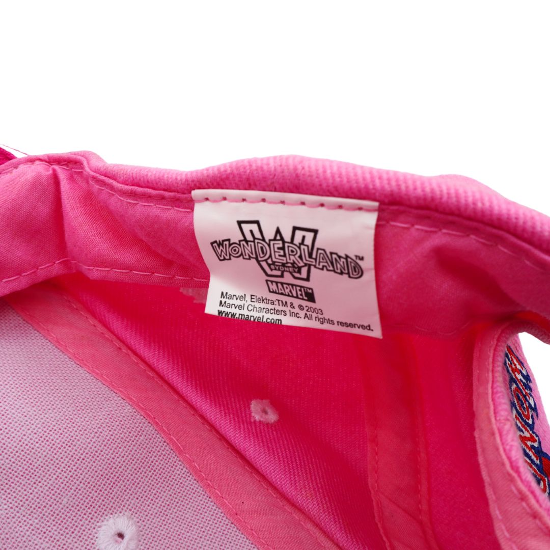 Close-up of the interior lining of a bright pink Wonderland Marvel hat, showing the white sewn-in label with black printed Wonderland Marvel branding.