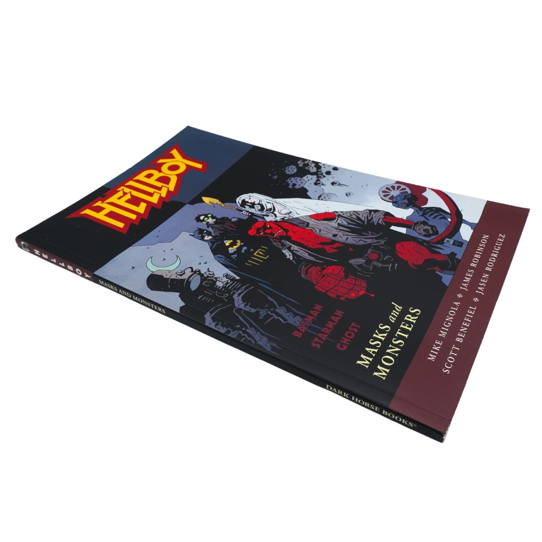 The comic book 'Hellboy: Masks and Monsters' laid out at an angle on a clean white background. The cover features a dark, detailed illustration of Hellboy with his signature red mask and black background, with the title 'Hellboy' in bold yellow letters.