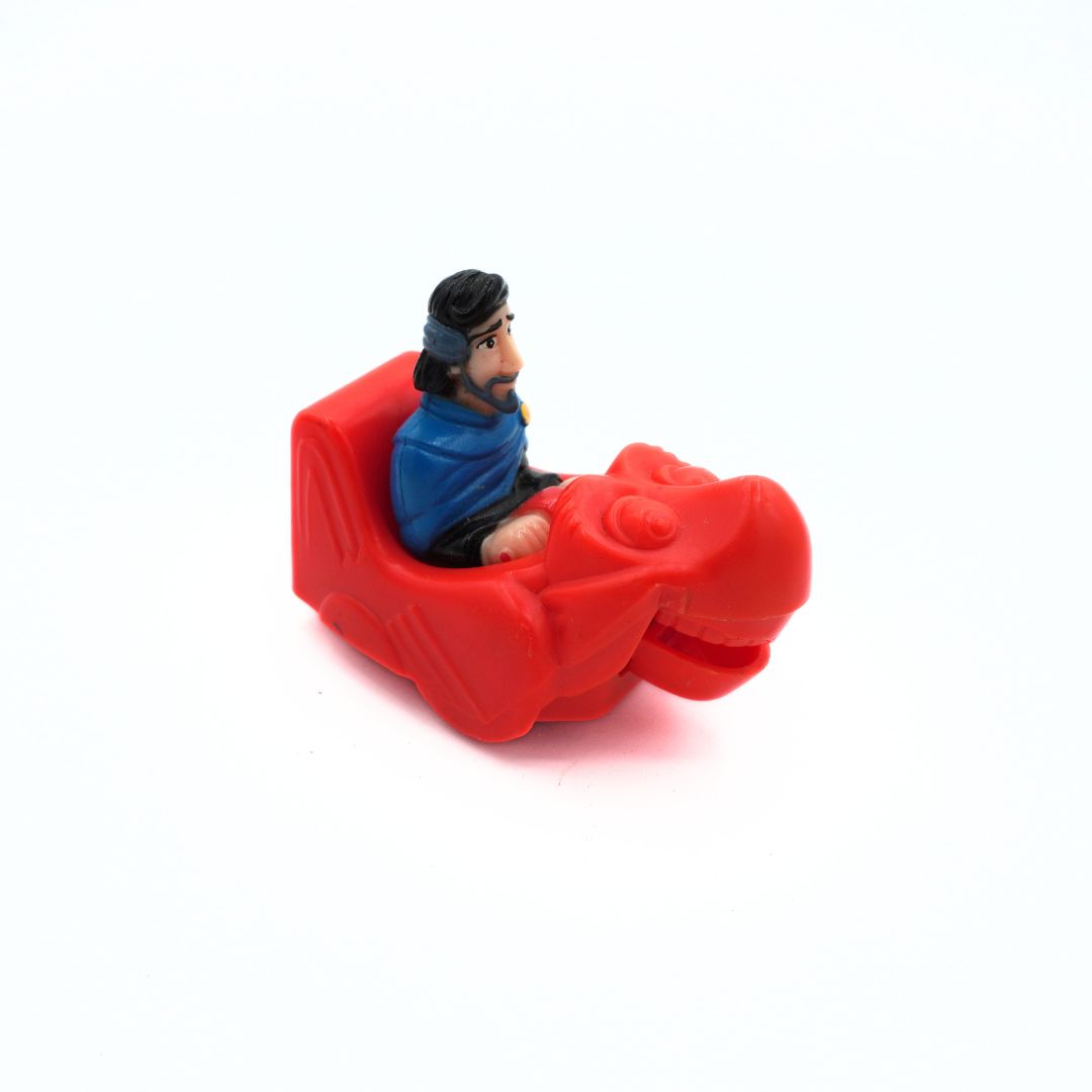 A small red plastic toy figure of a seated man with a beard and black head covering, positioned on a plain white background.