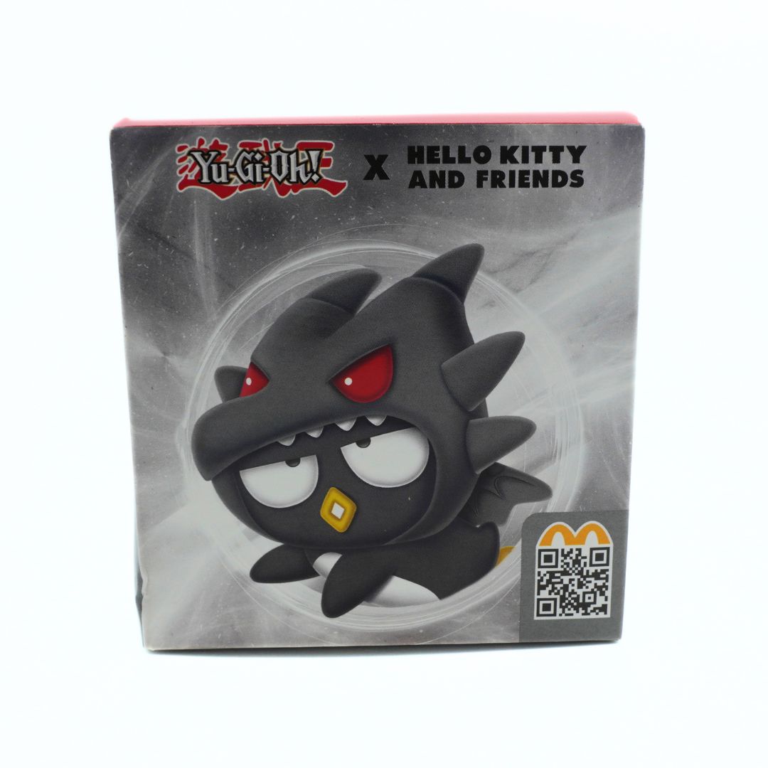 Yu-Gi-Oh! x Hello Kitty and Friends McDonalds toy box featuring a black cartoon monster with red eyes and a gold mouth, shown on a white background.