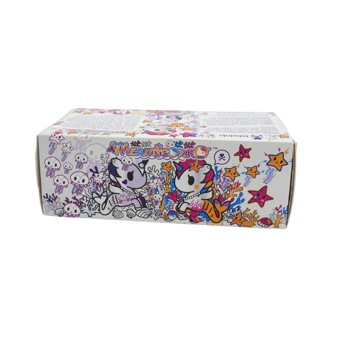 Photo of a colourful Mermicorno Tokidoki box with a set of two purple and white vinyl figurines