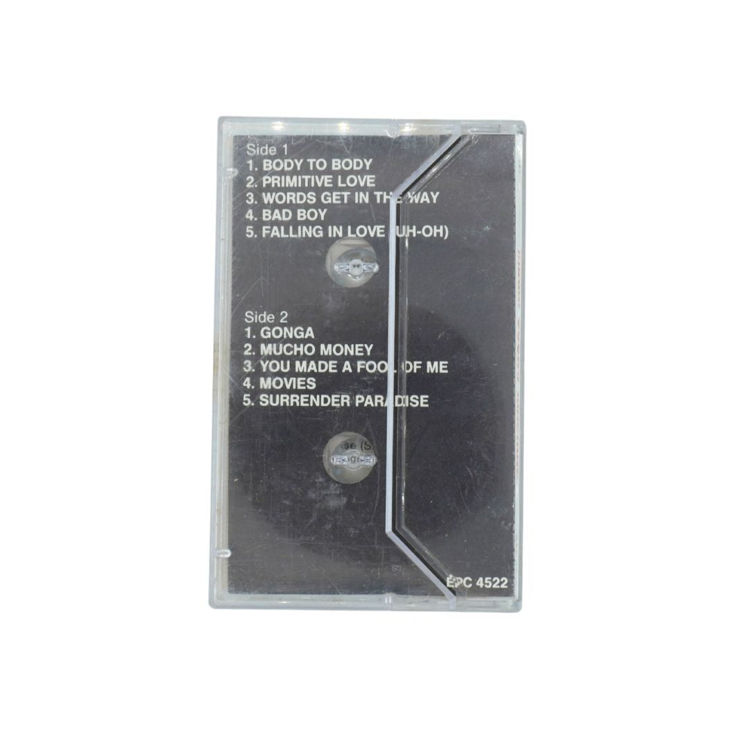 Black cassette case holding a Miami Sound Machine tape with two sides