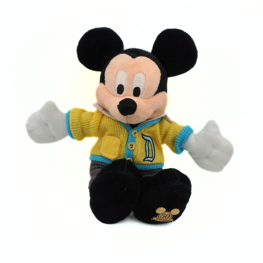 Plush toy of a character in a yellow sweater with a blue trim on a white background
