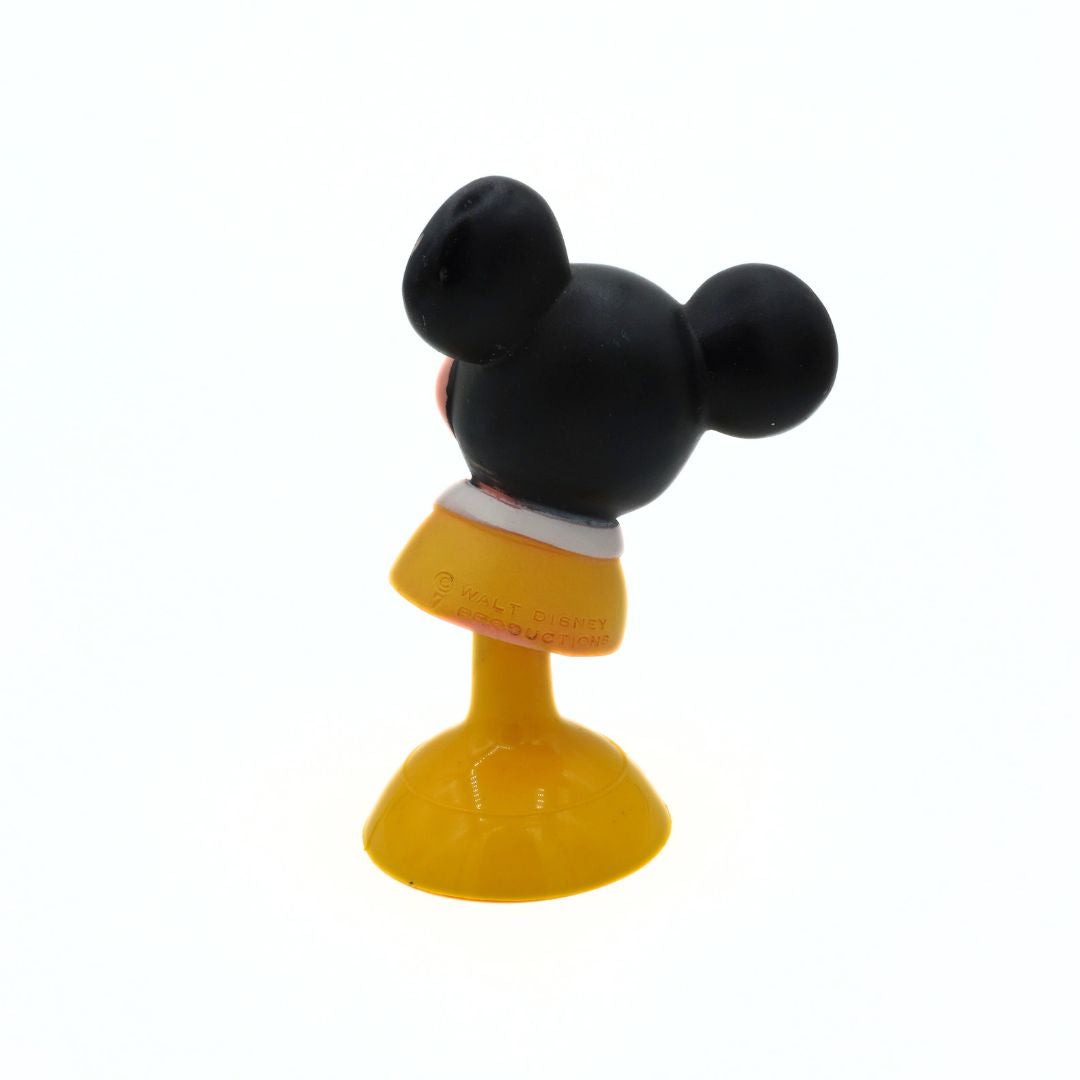 Small figurine of a character with black ears and yellow body on a white background