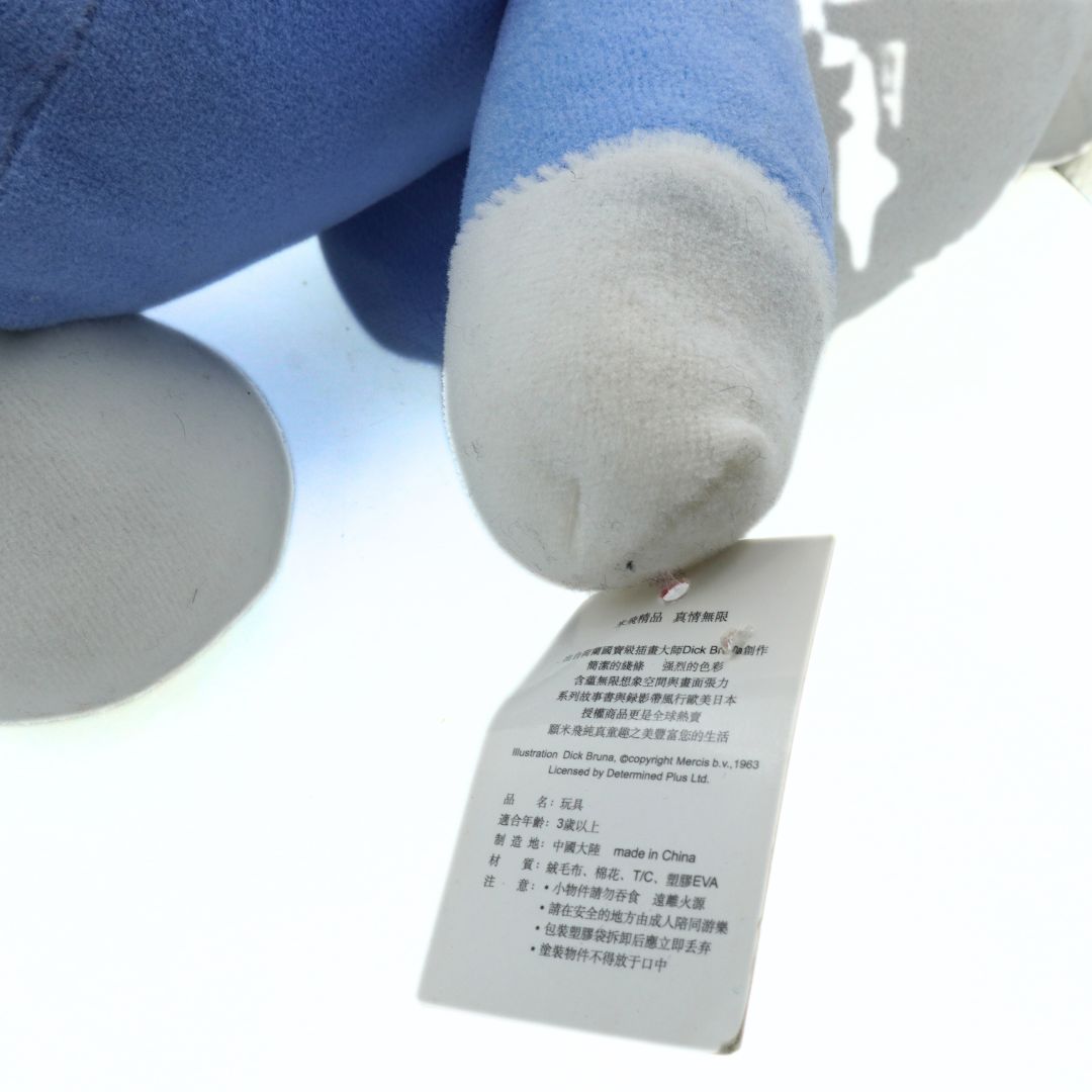 Blue plush toy with a label on a white background